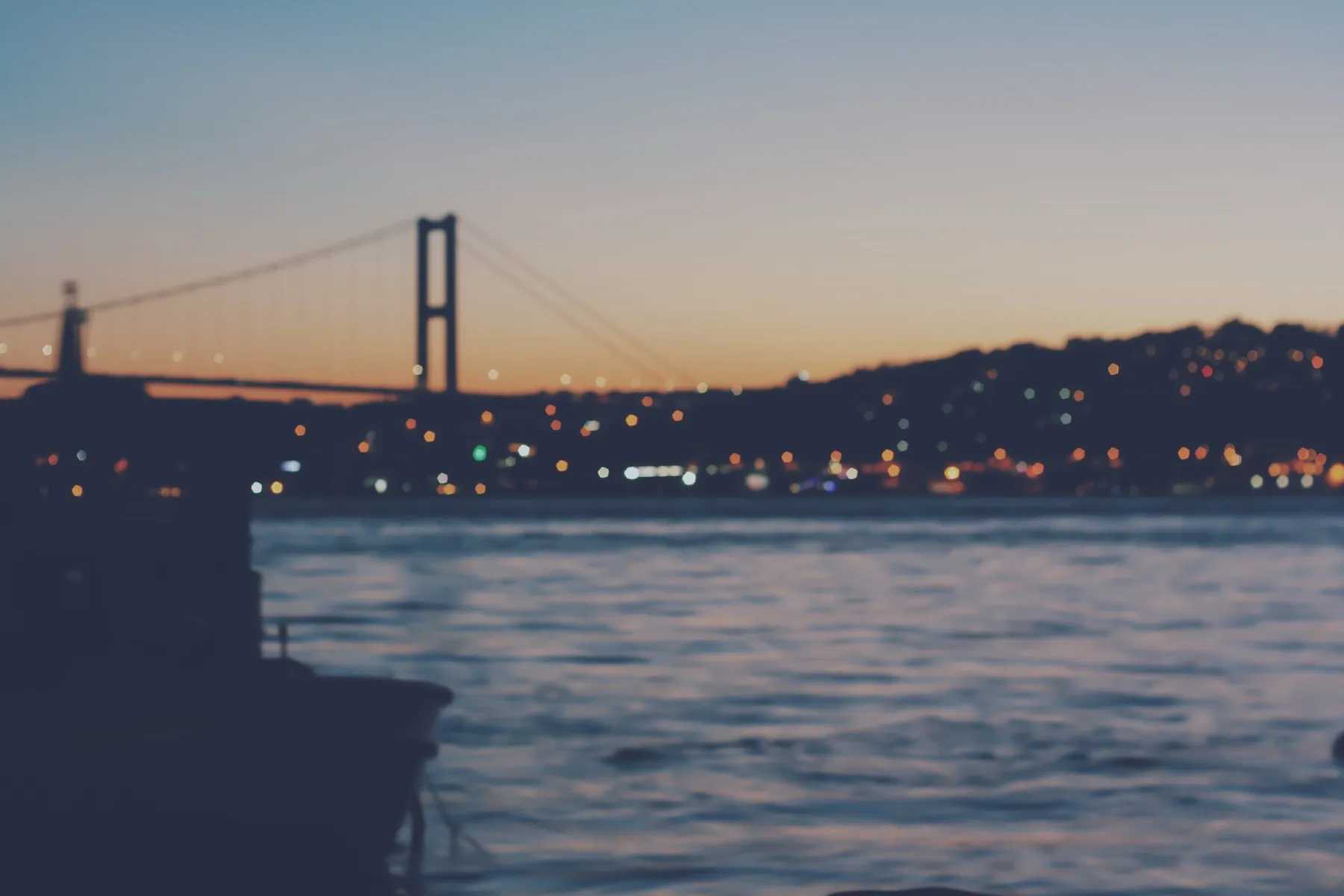 The Bosphorus Bridge and the shore lights at dusk